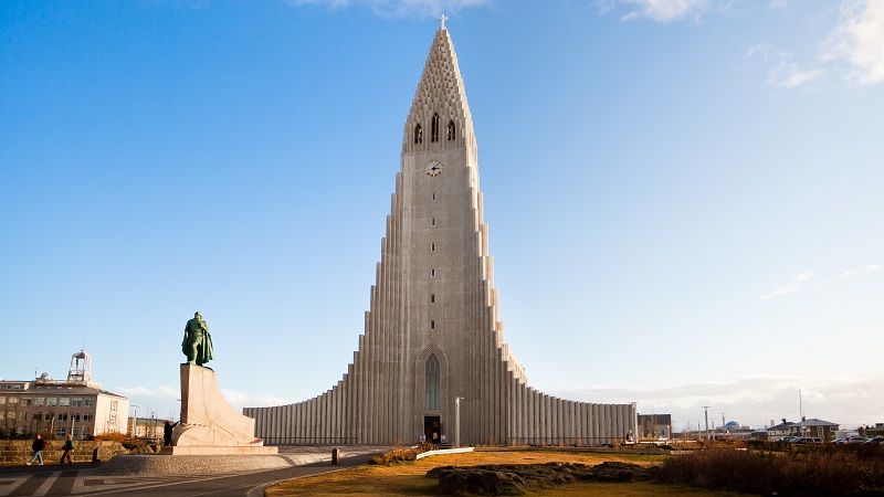 Den säreget utformade Hallgrimskirkja i Reykjavik, i grå sten mot en blekblå himmel.